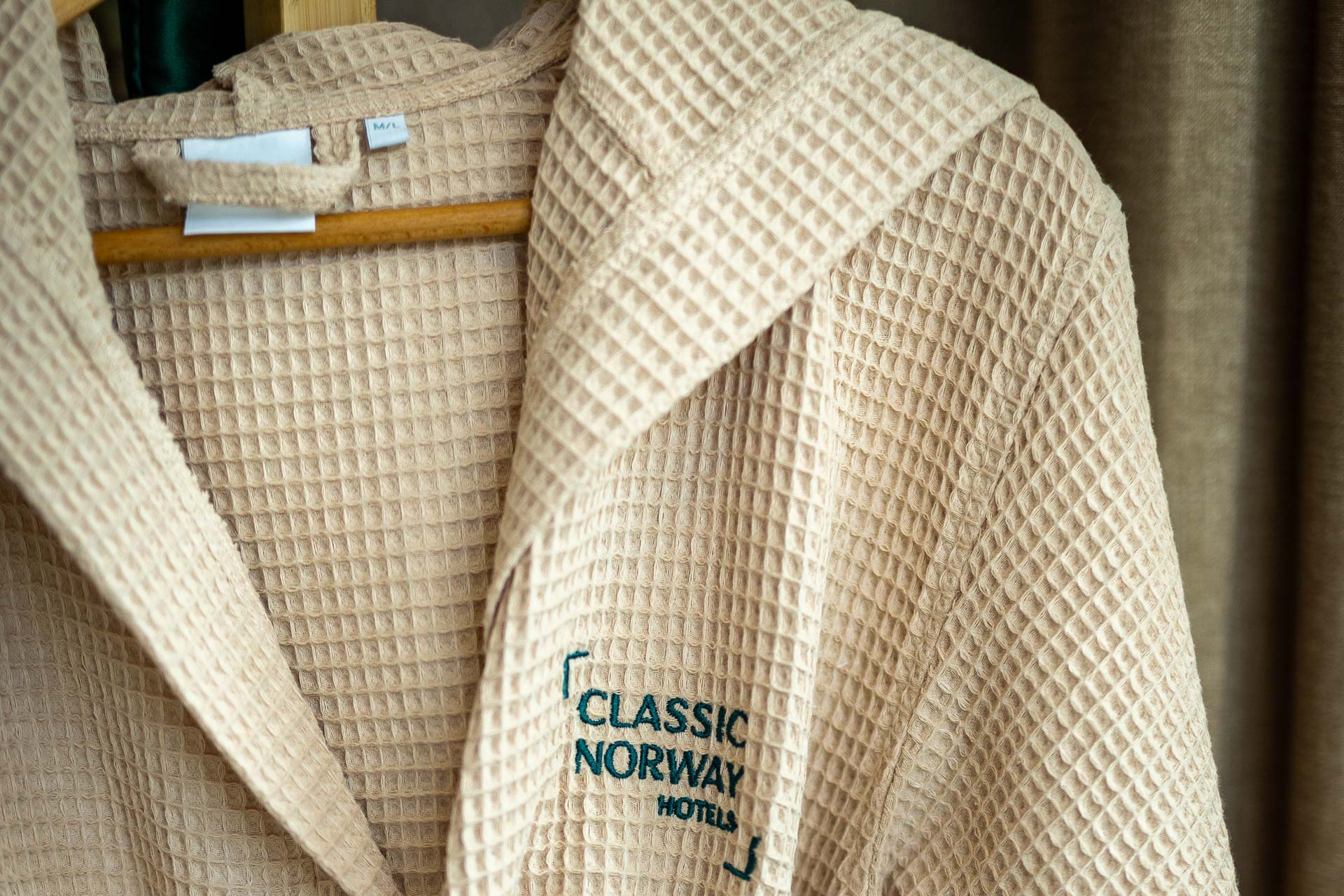 Beige badekåpe med brodert Classic Norway Hotels-logo